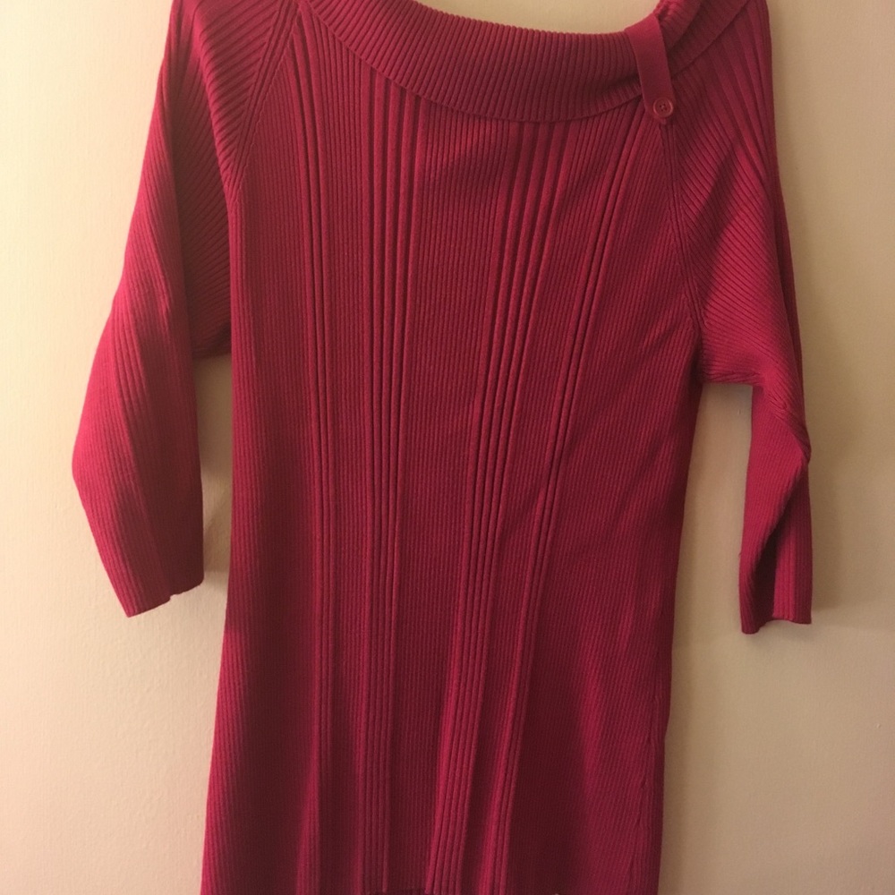 Sweater with a decorative button on the collar.